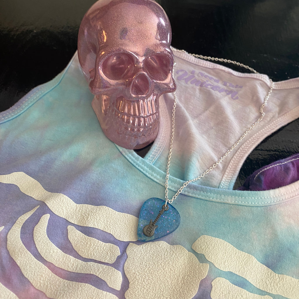 resin pink holographic skull on a cotton candy colored tank top and a blue guitar pick necklace