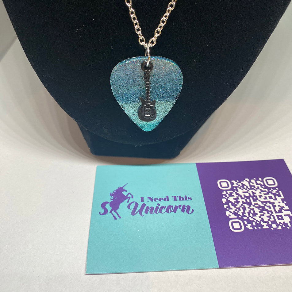 Aqua holographic fine glitter guitar pick in a silver colored cable chain and a mini black guitar charm