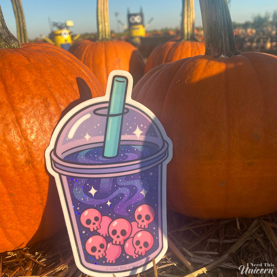 Galactic Haunted Boba sticker displayed among pumpkins and straw at a fall pumpkin patch, capturing spooky cute autumn vibes.