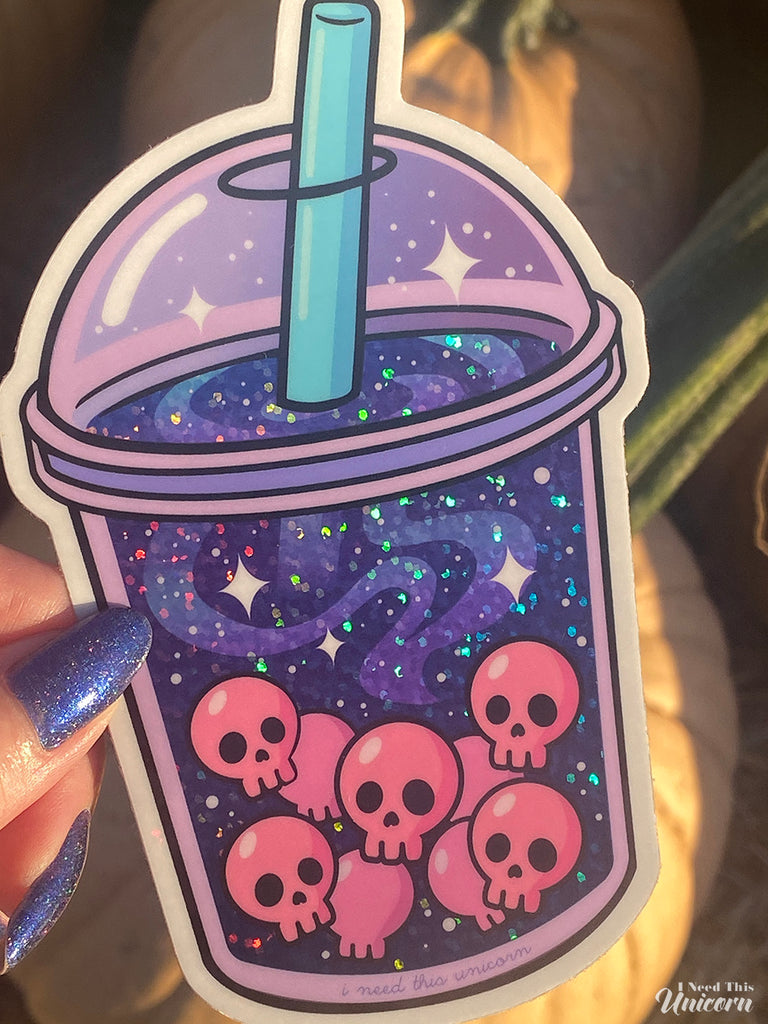 Close-up of holographic details on the Galactic Haunted Boba sticker, showing rainbow reflections across purple galaxy swirls and pink skull pearls.
