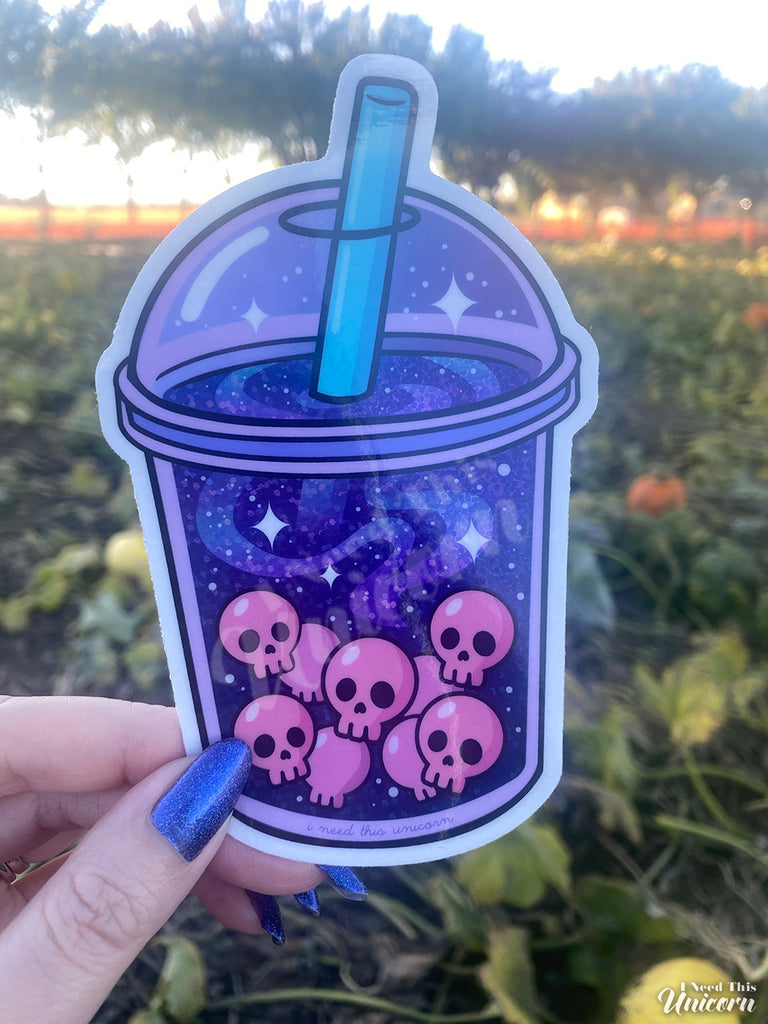 Holographic Galactic Haunted Boba sticker held in hand to show large 3.5 by 5 inch size and how the finish looks in the shade.